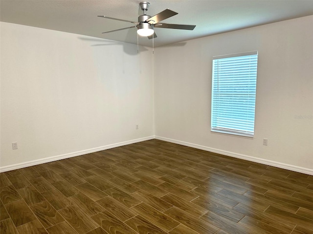 empty room with dark wood-type flooring, ceiling fan, and a wealth of natural light