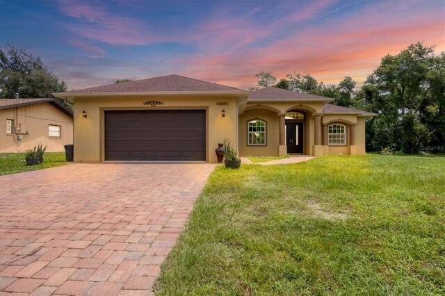 view of front facade with a garage and a lawn