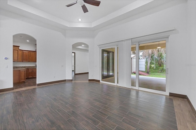 spare room featuring a tray ceiling, dark hardwood / wood-style floors, and ceiling fan