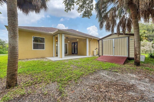 back of property featuring a shed, ceiling fan, and a patio area