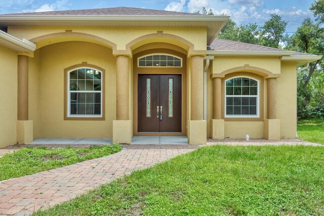 entrance to property with a lawn