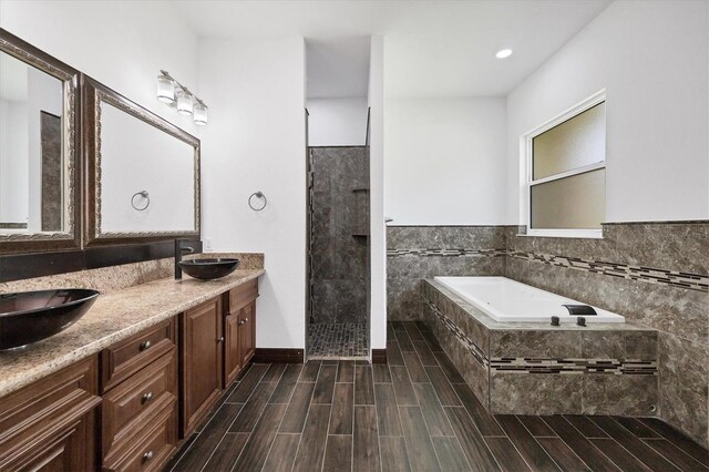 bathroom featuring shower with separate bathtub and double vanity