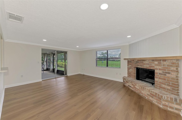 unfurnished living room featuring hardwood / wood-style floors, a textured ceiling, and ornamental molding