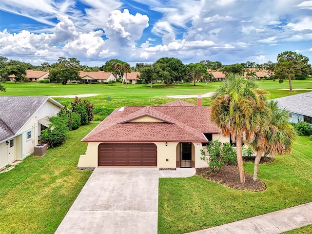 view of front of home with central AC unit, a garage, and a front lawn