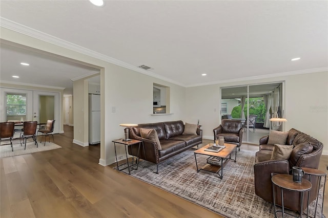 living room featuring dark wood-type flooring, ornamental molding, and french doors