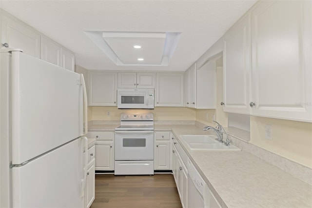 kitchen featuring white cabinetry, white appliances, a tray ceiling, and sink