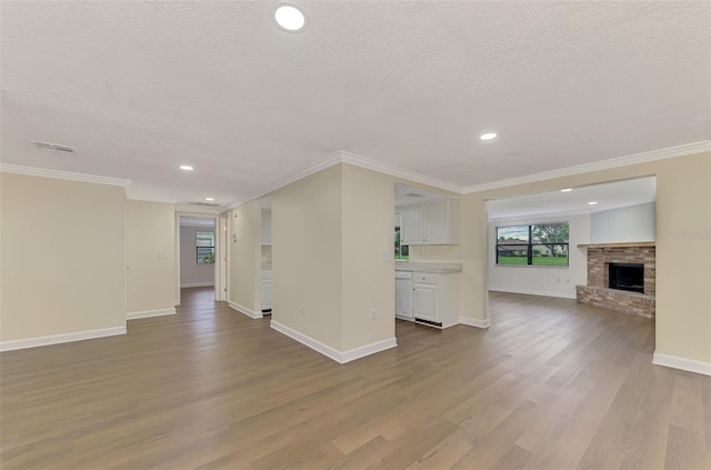 unfurnished living room with ornamental molding and light hardwood / wood-style flooring