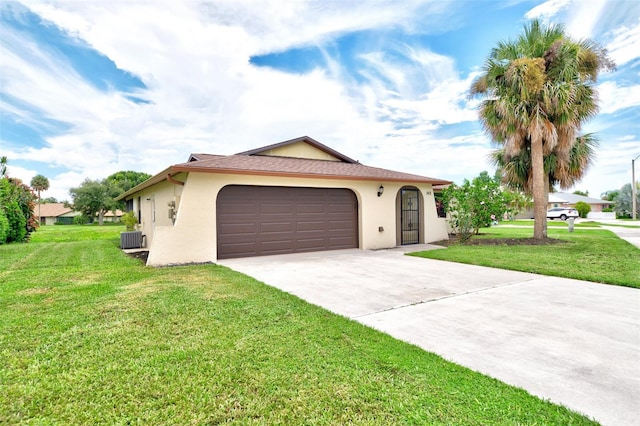 view of front of property featuring a garage, central AC, and a front yard