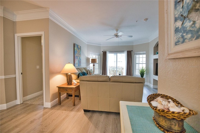 living room featuring light wood-type flooring, ceiling fan, and ornamental molding