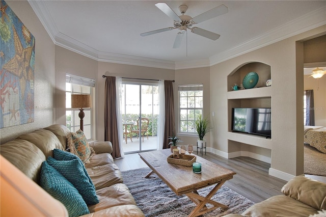 living room featuring light hardwood / wood-style floors, ornamental molding, and ceiling fan