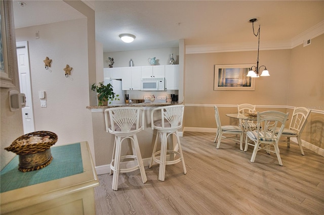 interior space with white cabinetry, a kitchen breakfast bar, light hardwood / wood-style flooring, and white appliances