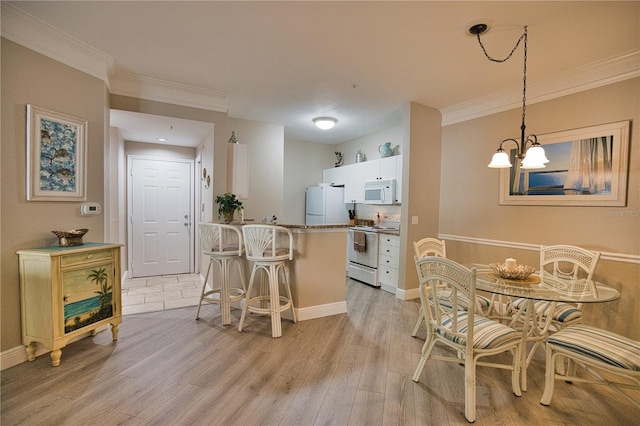 kitchen with white cabinetry, white appliances, light hardwood / wood-style floors, decorative light fixtures, and a kitchen bar