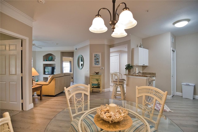 dining area with ceiling fan with notable chandelier and light hardwood / wood-style flooring