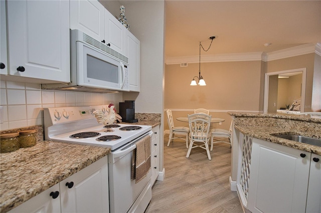 kitchen with white appliances, backsplash, light hardwood / wood-style floors, crown molding, and white cabinetry