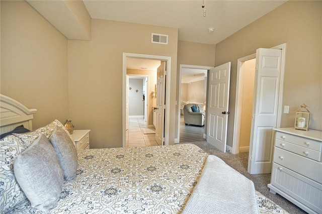 bedroom featuring light carpet and ensuite bath