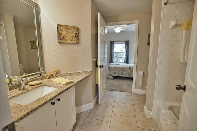 bathroom with vanity, tile patterned flooring, ceiling fan, and tiled shower / bath