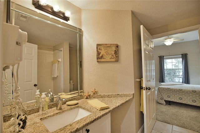 bathroom featuring vanity, tile patterned floors, ceiling fan, toilet, and a textured ceiling