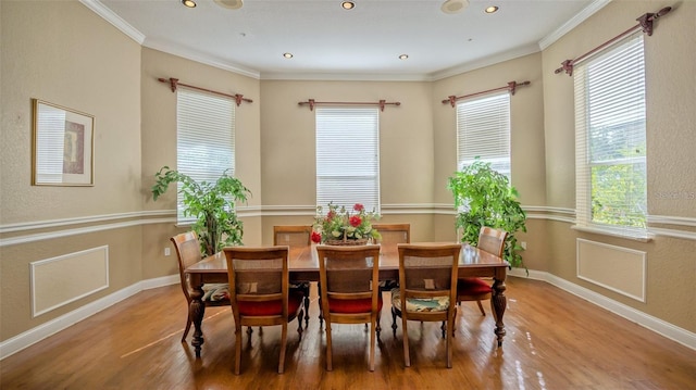 dining space featuring hardwood / wood-style floors, crown molding, and a healthy amount of sunlight