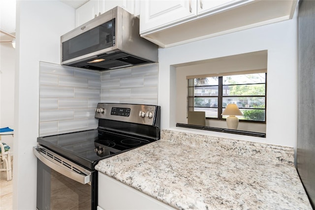 kitchen featuring appliances with stainless steel finishes, light stone countertops, tasteful backsplash, and white cabinets