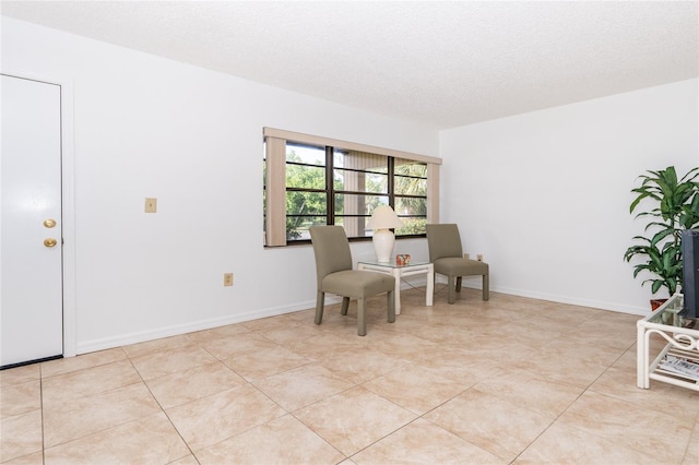 sitting room featuring light tile patterned flooring and a textured ceiling