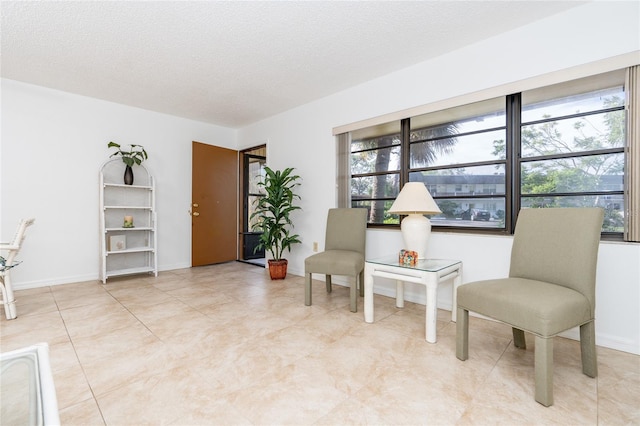 sitting room featuring light tile patterned flooring, a textured ceiling, and plenty of natural light