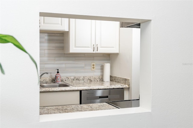 kitchen with decorative backsplash, sink, white cabinets, and dishwasher