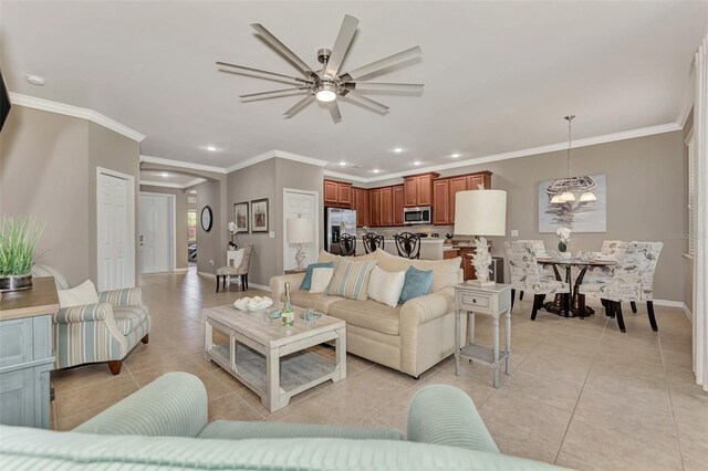 living room with ornamental molding, ceiling fan with notable chandelier, and light tile patterned floors