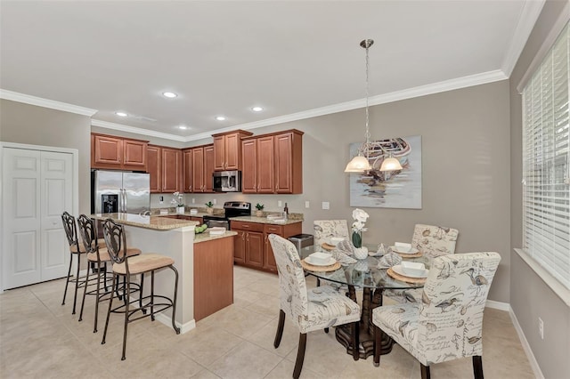 kitchen featuring stainless steel appliances, decorative light fixtures, a center island, and ornamental molding