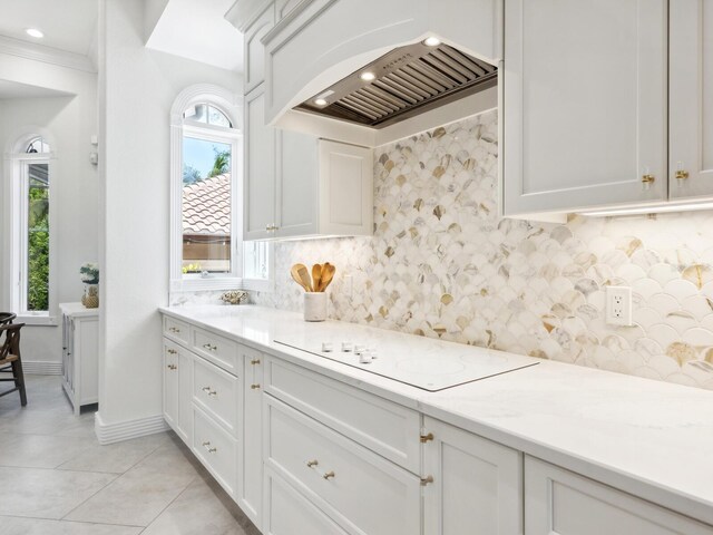 kitchen with custom exhaust hood, backsplash, light tile patterned flooring, and a wealth of natural light