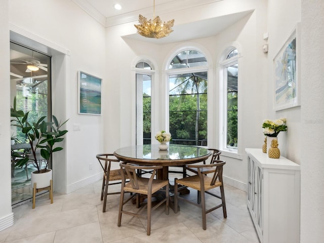 dining room featuring ornamental molding, ceiling fan with notable chandelier, and light tile patterned floors