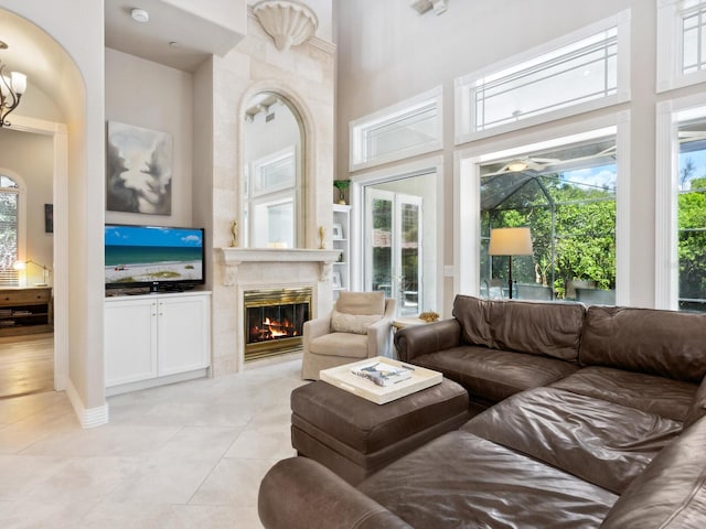 tiled living room with a towering ceiling and a premium fireplace