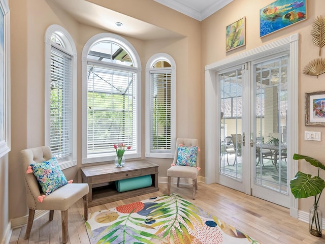 sitting room featuring crown molding, light hardwood / wood-style flooring, and french doors