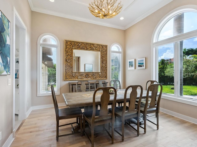 dining room with a wealth of natural light, crown molding, and light wood-type flooring