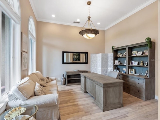 office space with light wood-style floors, visible vents, crown molding, and baseboards