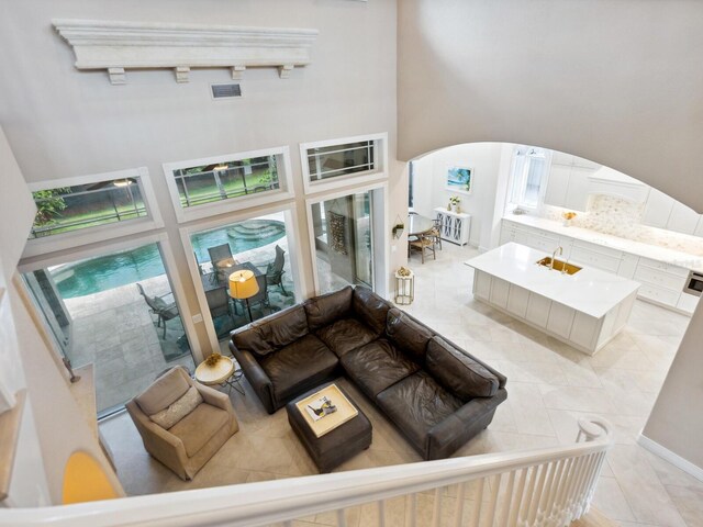 tiled living room featuring track lighting and a high ceiling