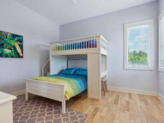 bedroom with light wood finished floors and baseboards