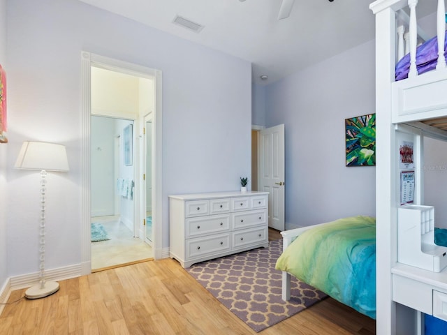 bedroom featuring visible vents, light wood-style flooring, connected bathroom, ceiling fan, and baseboards