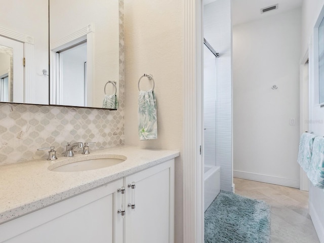 bathroom featuring tile patterned floors, shower / washtub combination, vanity, and tasteful backsplash