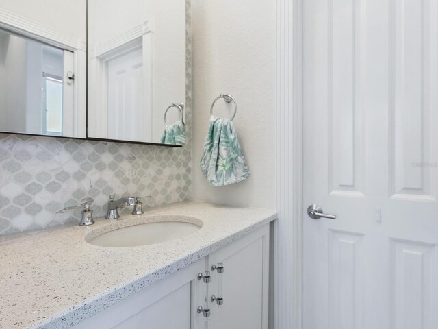 bathroom with vanity and tasteful backsplash