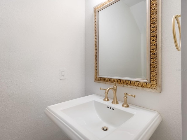 bathroom featuring a sink and a textured wall