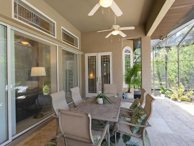 view of patio featuring ceiling fan and glass enclosure