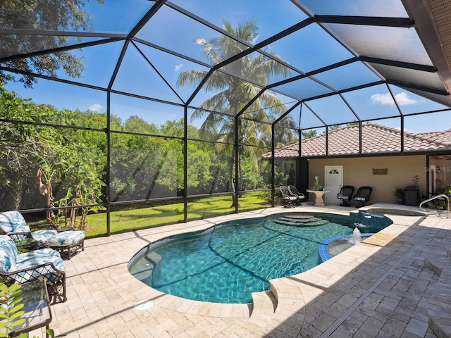 view of swimming pool featuring glass enclosure, a patio area, and a pool with connected hot tub