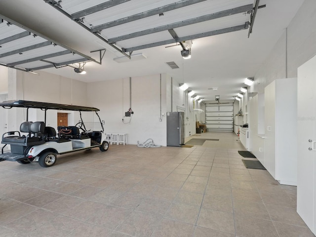 garage with a garage door opener and freestanding refrigerator