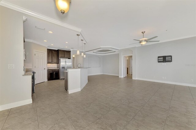 unfurnished living room featuring crown molding, sink, and ceiling fan