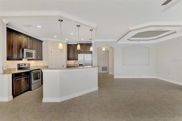 kitchen with light stone countertops, appliances with stainless steel finishes, crown molding, hanging light fixtures, and an island with sink