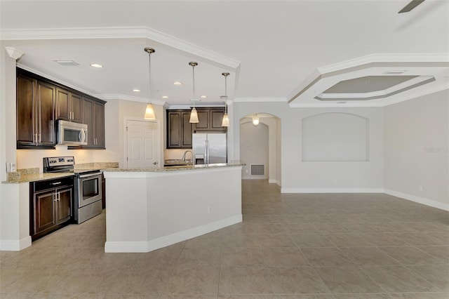 kitchen featuring appliances with stainless steel finishes, pendant lighting, an island with sink, dark brown cabinetry, and light stone countertops