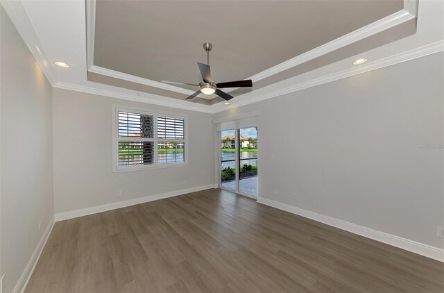 unfurnished room with a raised ceiling, crown molding, and hardwood / wood-style flooring