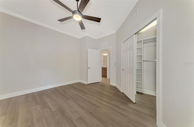 unfurnished bedroom featuring wood-type flooring, ornamental molding, a closet, and ceiling fan