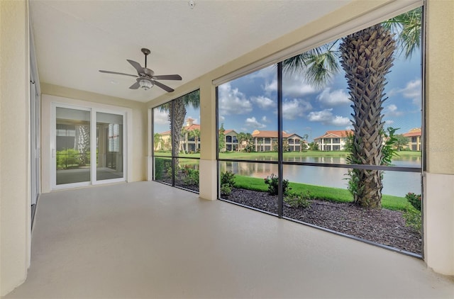 unfurnished sunroom featuring a water view and ceiling fan