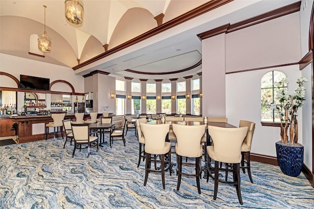 dining area featuring a towering ceiling and a healthy amount of sunlight